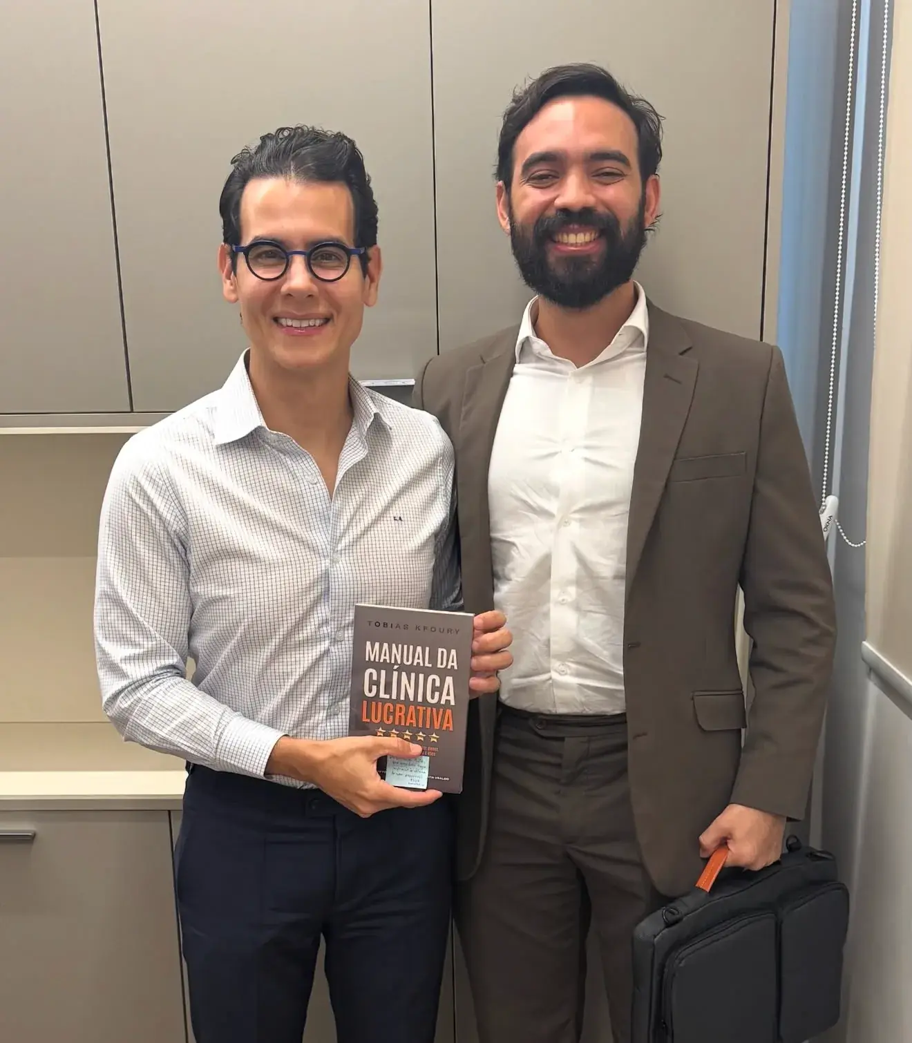 Gabriel Esteves com o Dr. Giuliano, que segura o livro Manual da Clínica Lucrativa